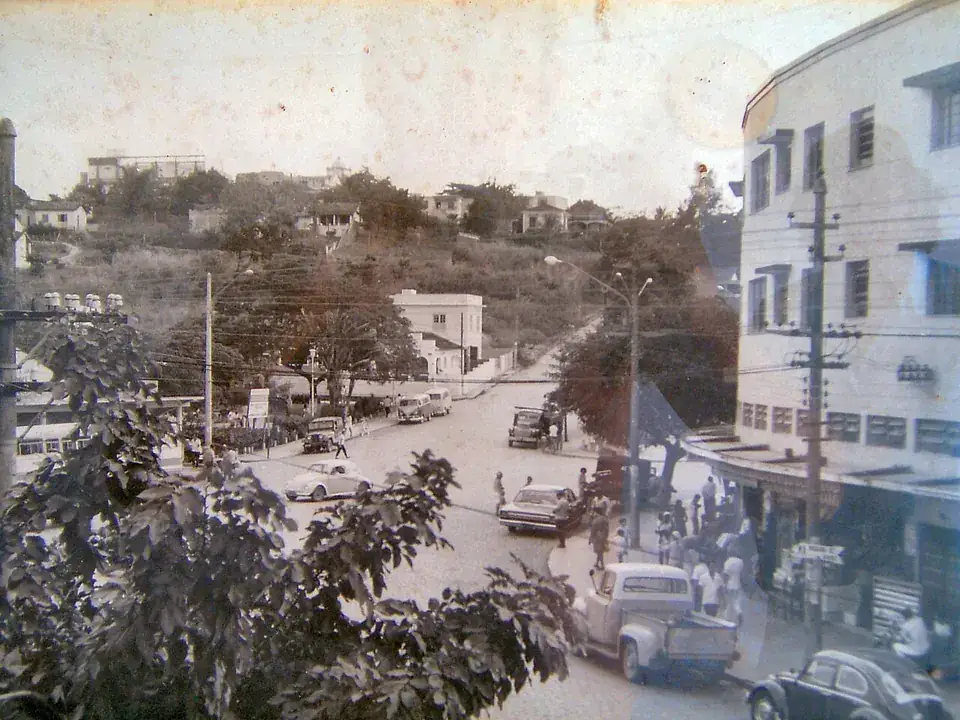Fotografia antiga do centro de Itaguaí nos anos 1950, com carros e pedestres na rua principal